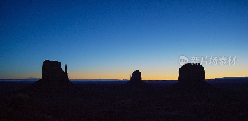 在一个晴朗的日子日出/日落亚利桑那纪念碑谷沙漠(东和西Mitten巴茨)的大型剪影岩层